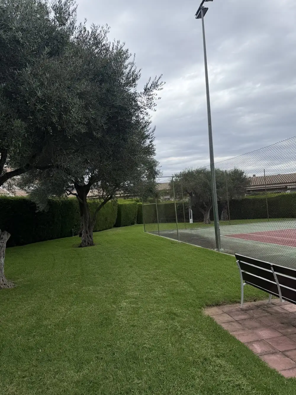 Zona ajardinada junto a una pista de tenis